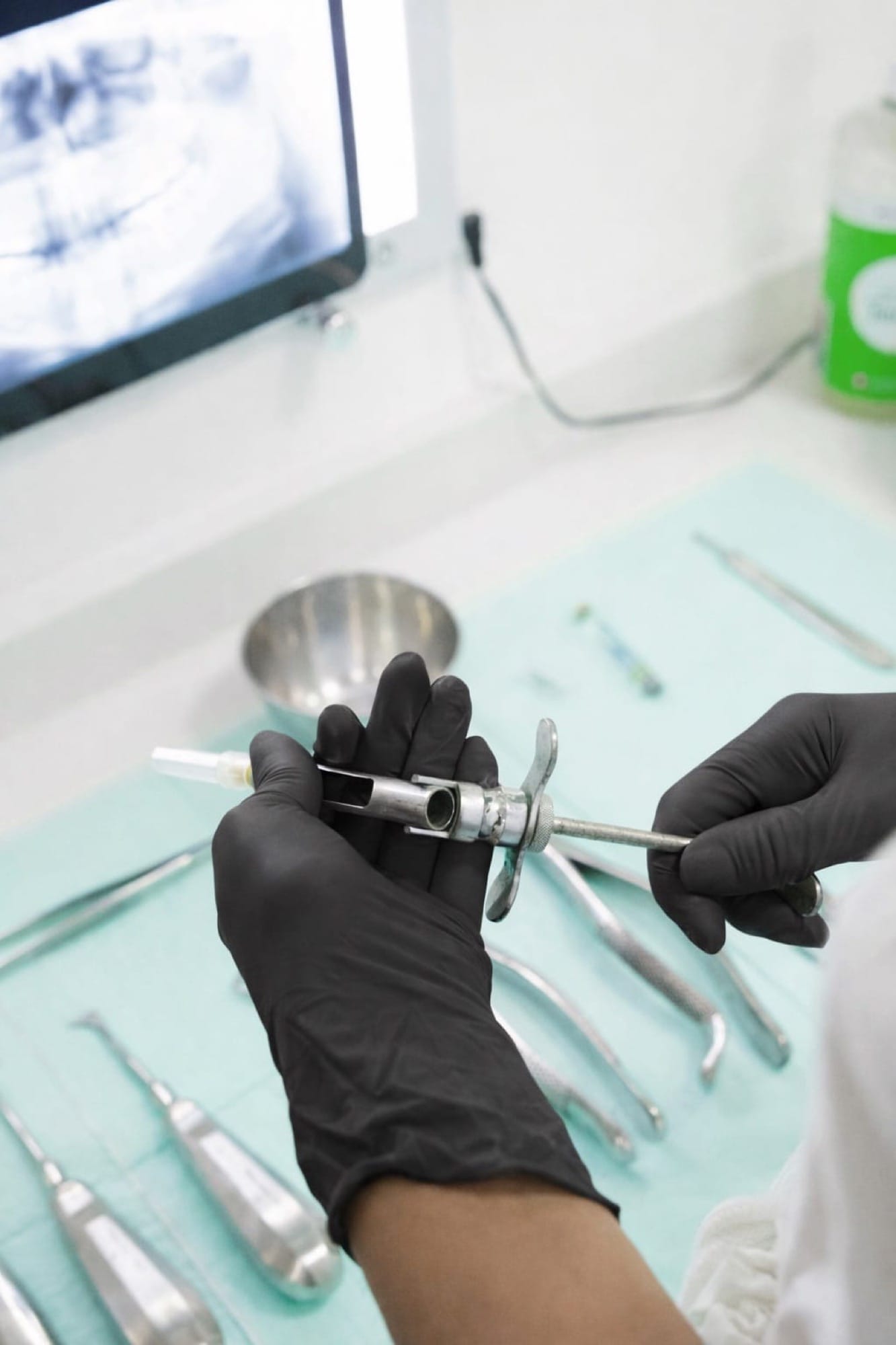 Zahnärztliche Instrumente auf Tablett: Eine Hand mit Handschuhen greift nach Werkzeugen in einer sauber vorbereiteten Praxisumgebung.